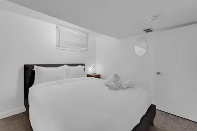 a white bedroom with a large bed with two teddy bears on it at 5 bed Luxury Home Steps to DT, River and Hospital in Calgary