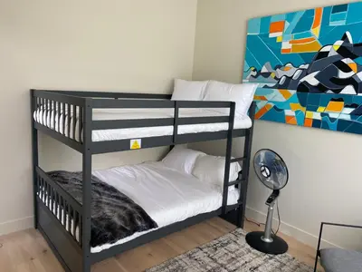 a black bunk bed in a room with a lamp at Large Modern Home in Squamish in Squamish