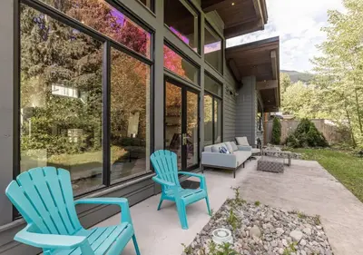 two blue chairs sitting on a patio in front of a house at Large Modern Home in Squamish in Squamish