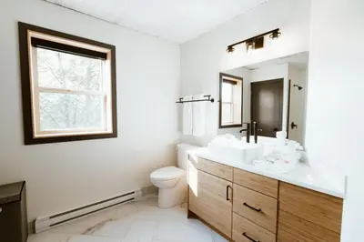 a bathroom with a sink and a toilet and a mirror at The Flying Steamshovel Inn in Rossland