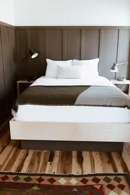 a bedroom with a large white bed and a rug at The Flying Steamshovel Inn in Rossland