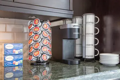 a kitchen counter with a coffee maker and cups on it at West King Edward Luxury Guest Home in Vancouver