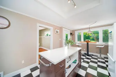 a kitchen with a black and white checkered floor at Charming 3BR Home Near UBC with Parking & Backyard in Vancouver