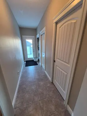 a hallway with a door and a tile floor at Sean Comfy Home in Edmonton
