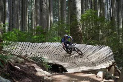 a man riding a bike on a wooden bridge at Awesome 2BR in Lynn Valley in North Vancouver