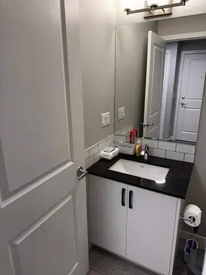 a bathroom with a white sink and a mirror at Newly Built 2-Bedroom, 2 full bath Basement Suite in Calgary