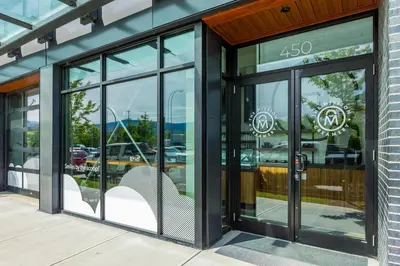a store front with glass doors with a bench inside at Beach Lake Resort in Kelowna