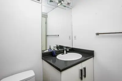 a bathroom with a sink and a mirror at Chic Central 4BDRM Home-King Bed-AirHockey-Mins DT in Edmonton