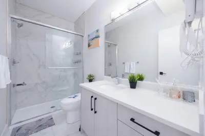 a white bathroom with a shower and a toilet at Newly Built Cozy 2BR Suite Langley Event Center in Langley
