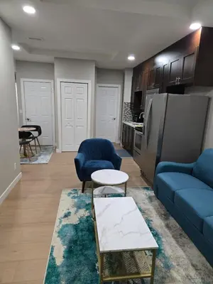 a living room with a blue couch and a kitchen at 2 Bedroom Secondary Suite in Calgary