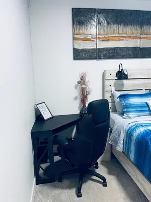 a desk with a chair next to a bed at Modern 2 bedroom guest suite in Calgary