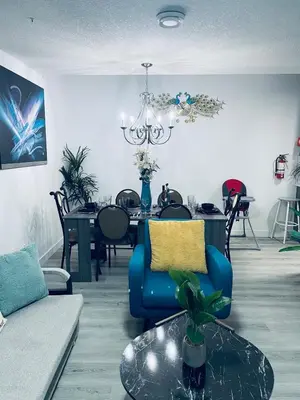 a living room with a table and a blue chair at Modern 2 bedroom guest suite in Calgary