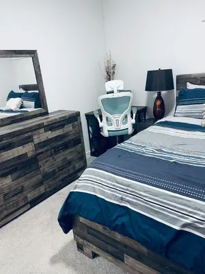 a bedroom with a bed and a mirror and a chair at Modern 2 bedroom guest suite in Calgary