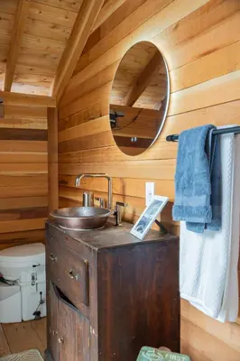 a wooden bathroom with a sink and a mirror at Lux Remote Glamping Hideaway in Ucluelet