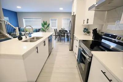 a kitchen with white countertops and a dining room at Edgemont Escape Large Groups, River Cree, WEM, Disney in Edmonton