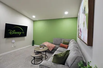 a living room with a gray couch and a green wall at Edgemont Escape Large Groups, River Cree, WEM, Disney in Edmonton