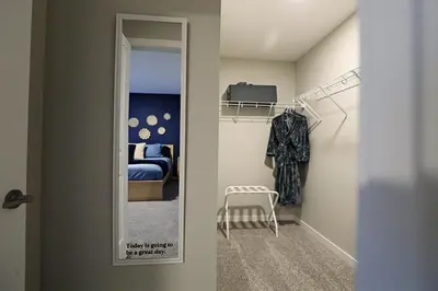 a hallway with a mirror and a bedroom at Edgemont Retreat, Groups, River Cree, WEM, Disney in Edmonton
