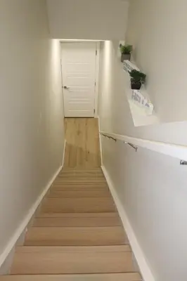 a stairway with a white wall and a white door at DJoshuas place in Edmonton