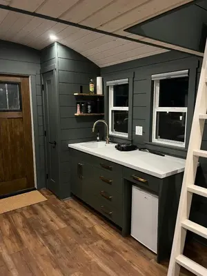 a kitchen with a sink and two windows at Sagebrush Caboose in Okanagan Falls