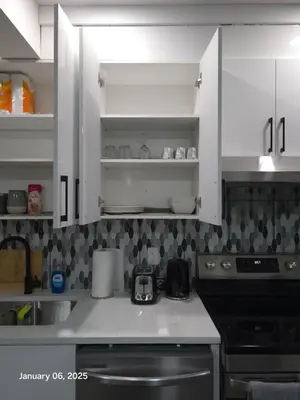a kitchen with white cabinets and a black stove at Lovely home in Northwest Calgary in Calgary