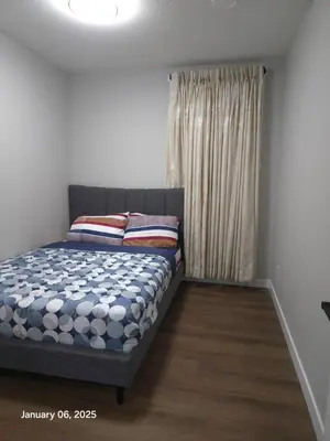 a bedroom with a bed with a pillow and a window at Lovely home in Northwest Calgary in Calgary
