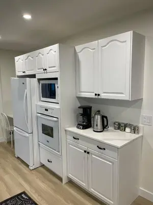 a kitchen with white cabinets and a white refrigerator at Lionsbay in Lions Bay