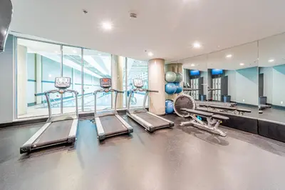 a gym with treadmills and machines in a building at Cozy Condo! Central Location! Plus One Free Parking! in Vancouver