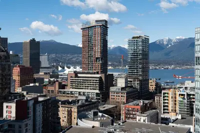 a city with skyscrapers and mountains in the background at Cozy Condo! Central Location! Plus One Free Parking! in Vancouver