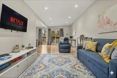 a living room with a blue couch and a tv at Comfy, Cozy, Central Calgary, 2BR and 1BTH in Calgary
