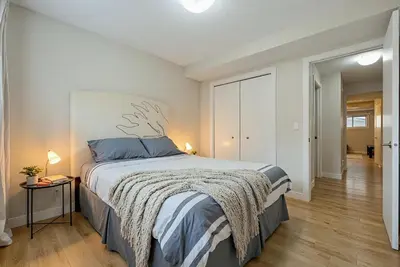 a bedroom with a large bed with blue pillows at Cozy and Welcoming 2BR Basement Suite In The Heart of Calgary in Calgary