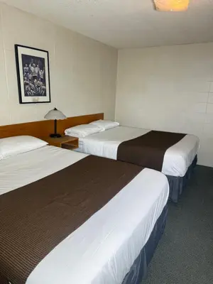 a hotel room with two beds and a lamp at Sunrise Motel in Consort