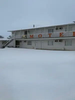 a white building with orange letters on it at Sunrise Motel in Consort