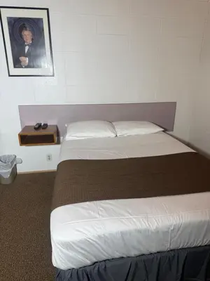 a bedroom with two beds and a picture on the wall at Sunrise Motel in Consort