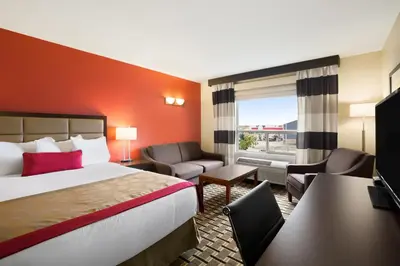 a hotel room with a bed and a desk at Ramada by Wyndham Edson in Edson