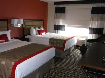 a hotel room with two beds and a desk at Ramada by Wyndham Edson in Edson
