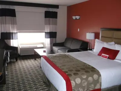 a hotel room with a bed and a couch at Ramada by Wyndham Edson in Edson
