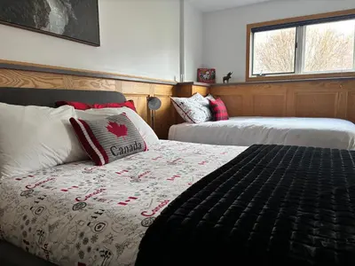 a bedroom with two beds and two windows at Amazing Views, Northern Lights, Stargazing Entire Guest Suite in Golden, BC Canada in Golden