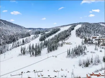 a ski slope with trees and a ski lift at Main Village, Ski-in Ski-out, Hot Tub, Condo in Sun Peaks