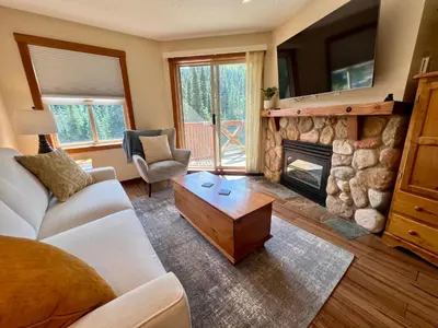 a living room with a couch and a fireplace at Main Village, Ski-in Ski-out, Hot Tub, Condo in Sun Peaks