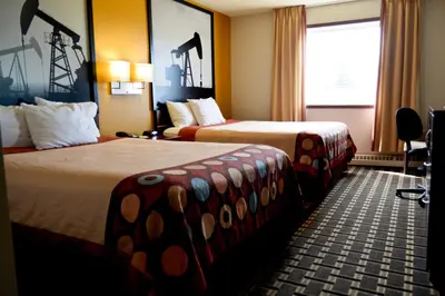 a hotel room with two beds and a window at Super 8 by Wyndham Fox Creek in Fox Creek