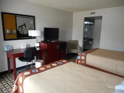a hotel room with two beds and a desk at Super 8 by Wyndham Fox Creek in Fox Creek