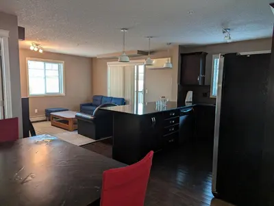 a kitchen and living room with a table and a couch at Well located Condo in North of Calgary in Calgary