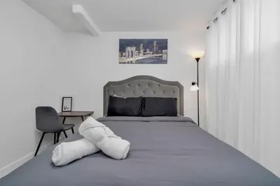a bedroom with a bed and a table with a chair at Private Chic Orchard Getaway in Edmonton
