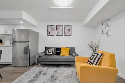 a living room with a couch and a refrigerator at Private Chic Orchard Getaway in Edmonton