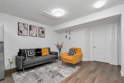 a living room with a couch and a chair at Private Chic Orchard Getaway in Edmonton