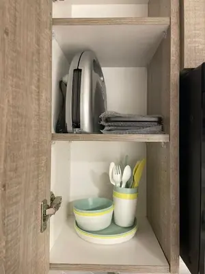 a cupboard with bowls and utensils in it at Calgary Cozy Nest 2BR Suite in Calgary