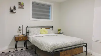 a bedroom with a bed with a yellow pillow on it at Calgary Cozy Nest 2BR Suite in Calgary