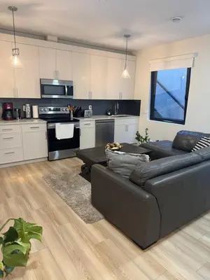 a living room with a couch and a kitchen at Beautiful 2 Bedroom suite in White Rock
