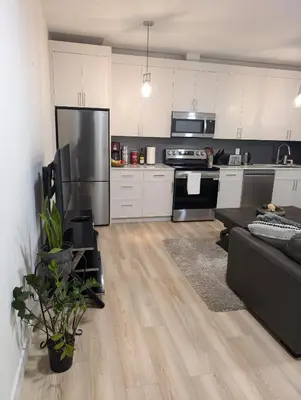 a kitchen with a stainless steel refrigerator and a couch at Beautiful 2 Bedroom suite in White Rock