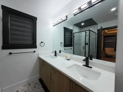 a bathroom with two sinks and a large mirror at The Luxe Escape Calgary I 3BR Vacation Home in Calgary
